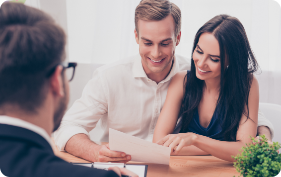 Couple reviewing paperwork, smiling.