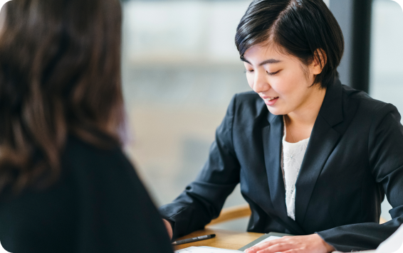 Woman in suit looking at document.