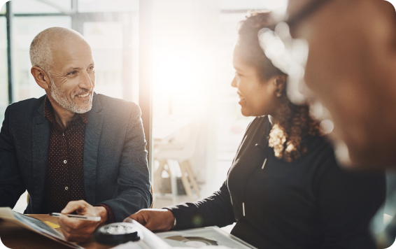 Smiling businessman talking to colleague in office.