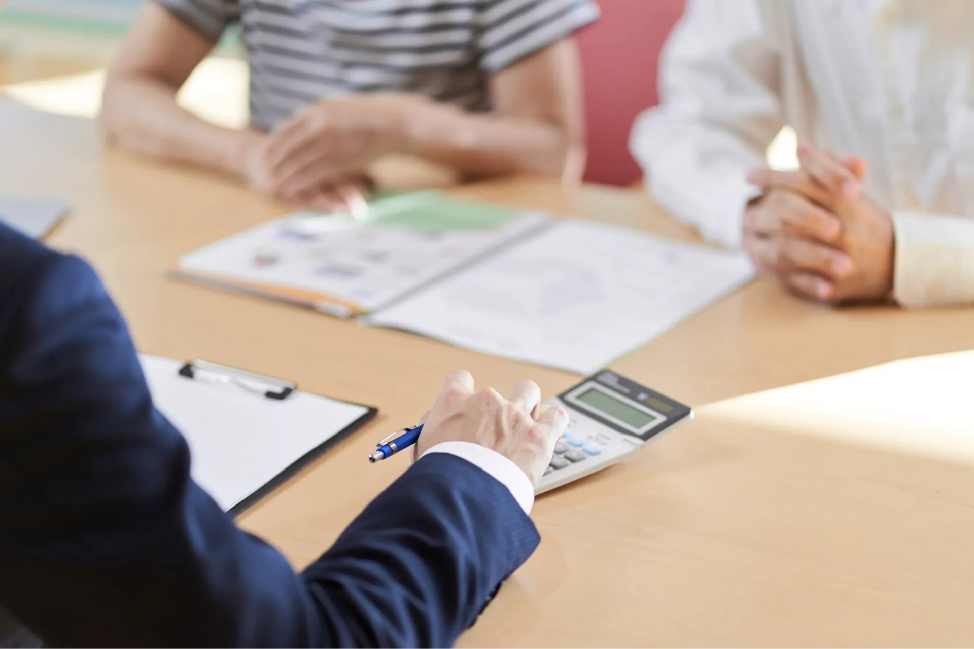 A person sitting at a table with papers and a calculator.