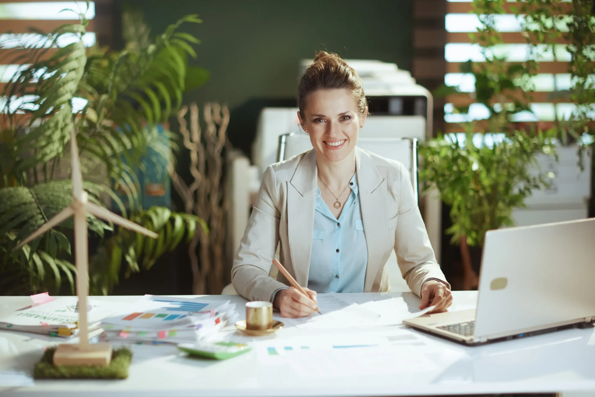 Smiling businesswoman working at desk with laptop.