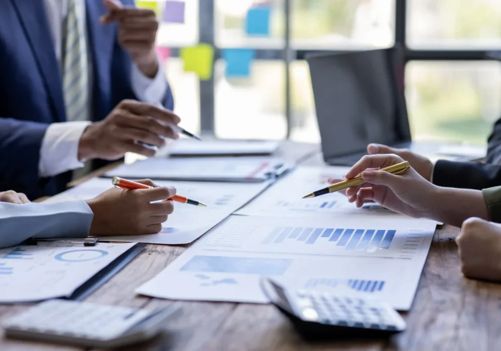 Businesspeople analyzing data with pens.